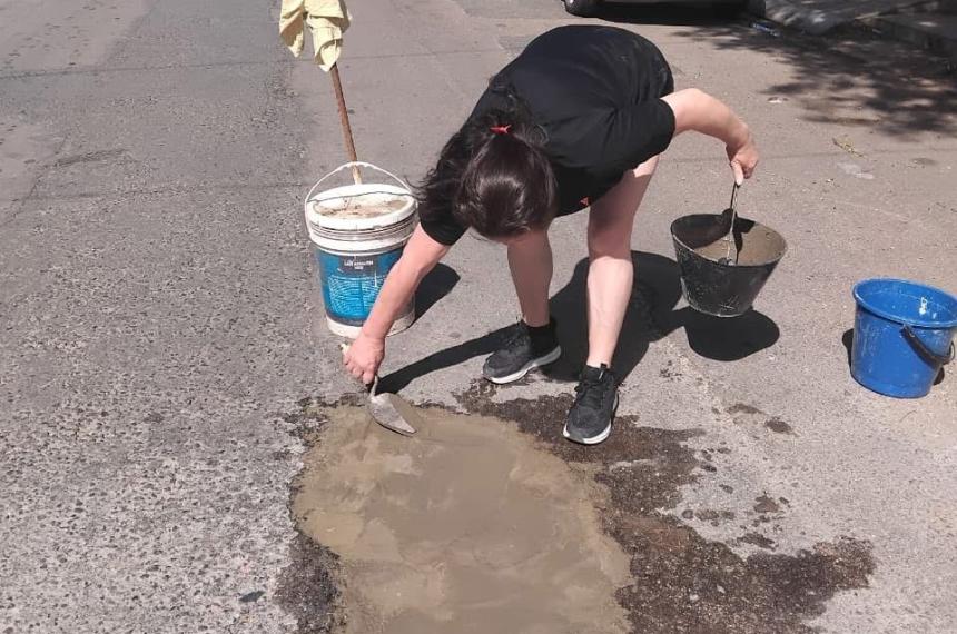 Una vecina en plena tarea de tapado del pozo