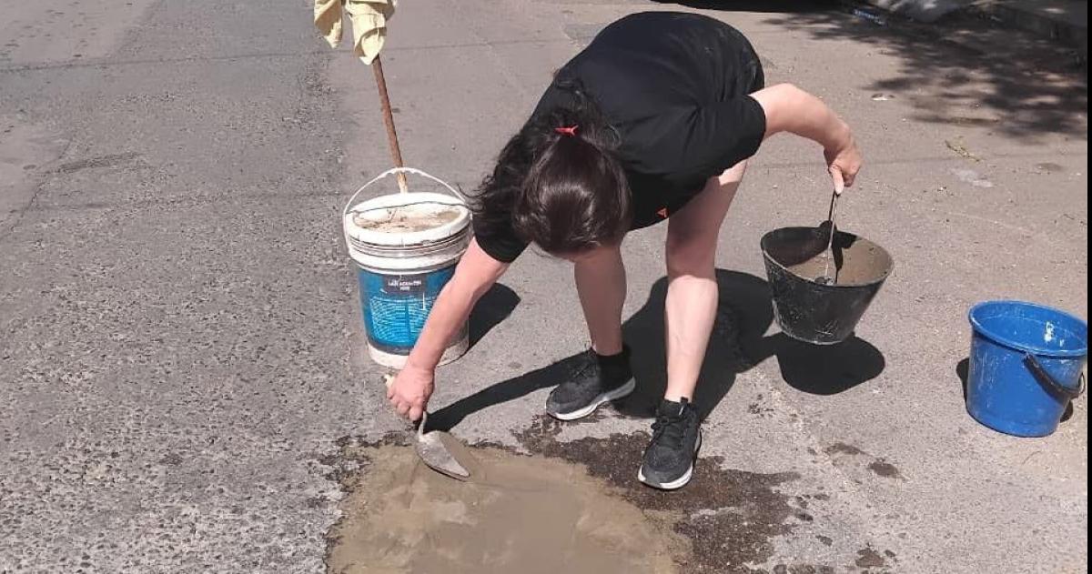 Una vecina en plena tarea de tapado del pozo