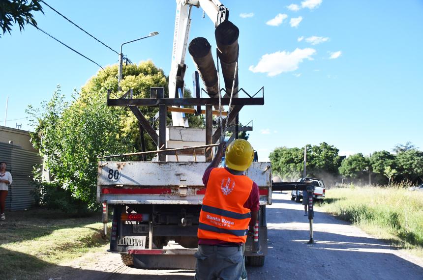 Un empleado municipal ajusta dos postes que le bajaron al Grupo Clarín
