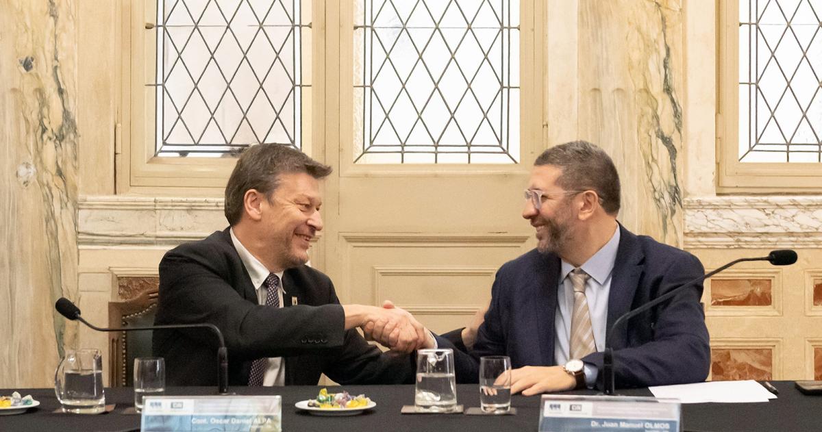 Oscar Alpa y Juan Manuel Olmos al firmar el convenio