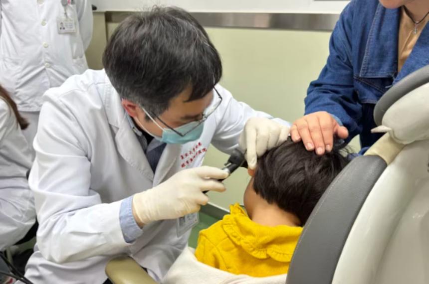 El Dr Yilai Shu examina a un paciente joven en el Hospital de Ojos y Otorrinolaringología de la Universidad de Fudan en China
